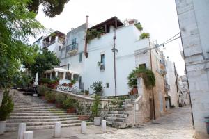 a white building with stairs and potted plants at Suite San Gaetano in Conversano