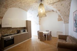 a kitchen with white cabinets and a table in a room at Suite San Gaetano in Conversano
