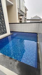 a blue tile swimming pool in front of a house at Villa risky A11 in Tlekung
