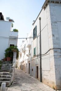 an empty alley with white buildings and stairs at Suite San Gaetano in Conversano +10 photos