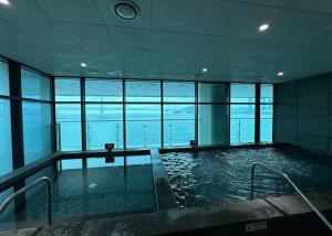 a large swimming pool in a building with windows at 광안비치스테이&Spa in Kwangan-dong