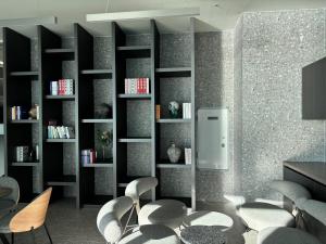 a living room with black book shelves and chairs at 광안비치스테이&Spa in Kwangan-dong