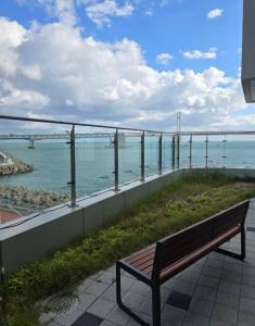 a bench sitting on a balcony looking at the ocean at 광안비치스테이&Spa in Kwangan-dong