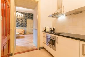 a kitchen with a stove top oven next to a living room at The Royal Suite II - R.Q.C. in The Hague
