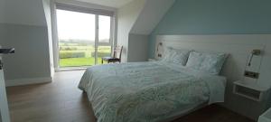 a bedroom with a bed and a large window at Lighthouse view in Garryvoe