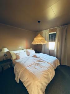 a bedroom with a large bed and a chandelier at Large apartment with parking in Sandefjord