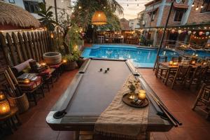 a pool table in front of a swimming pool at Gecko Backpackers Hostel in Ninh Binh