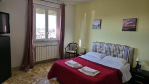 a bedroom with a bed with red sheets and a window at Hope Apartment in Pisa