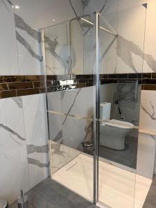 a glass shower in a bathroom with a toilet at Casa la Perla Solo adultos in Béznar +79 photos