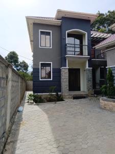 a blue house with a stone driveway at Vine Suites Mbarara Fully Furnished 1BR - Ideal for Short & Long Stays in Mbarara