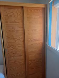 a wooden door in a room with a window at Le goéland in Port Leucate