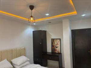 a bedroom with a bed and a yellow ceiling at Q2Shortlet Apartment in Isheri-Olofin