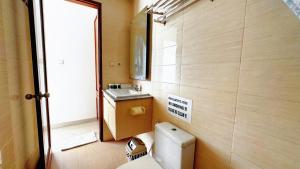 a small bathroom with a toilet and a sink at Cozy Guest House Canggu in Kerobokan