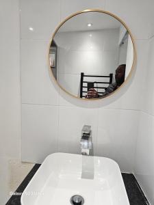 a man taking a picture of a sink in a bathroom at Emmanuel INN XI in Pierrefitte-sur-Seine +8 photos