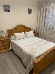 a bedroom with a wooden bed with two pillows at Chalet Bordones Playa in Bordons