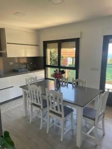 a kitchen with a dining room table and chairs at Chalet Bordones Playa in Bordons