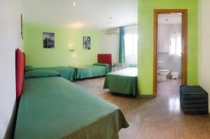 Habitación con 2 camas y paredes verdes en Hostal Apolo Trece en Santa Fe