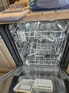 a dishwasher in a drawer with dishes in it at Lake apartment with terrace in Nidau +15 photos