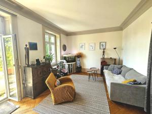 a living room with a couch and a tv at Lake apartment with terrace in Nidau