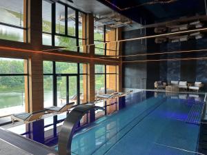 a large swimming pool with chairs in a building at Rezidence u Jezera in Jeseník
