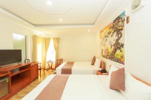 a hotel room with two beds and a flat screen tv at HP Truong Hotel Phu Quoc in Phú Quốc