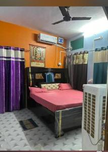 a room with a bed with pink sheets and curtains at Jagdamba home stay in Ayodhya