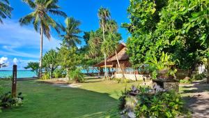 a resort on the beach with palm trees and the ocean at Manoa Kei Boutique Villas in Letman