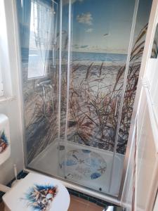 a bathroom with a shower with a picture of the beach at Bungalow Mika und Lizzy in Koserow