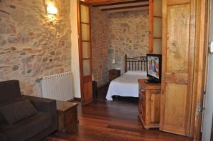 a bedroom with a bed and a couch and a tv at Casa Cundaro in Girona