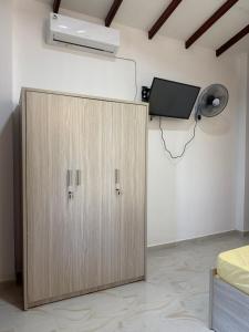 a wooden cabinet in a room with a tv on the wall at Hantana Villa in Kandy