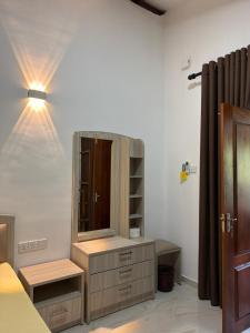 a bedroom with a dresser with a mirror and a light at Hantana Villa in Kandy