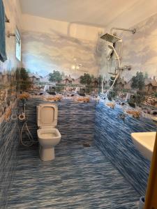 a bathroom with a toilet and a painting on the wall at Hantana Villa in Kandy