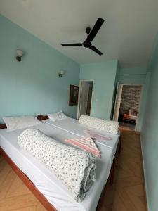 a bedroom with two beds and a ceiling fan at Hotel Unicorn in Pokhara