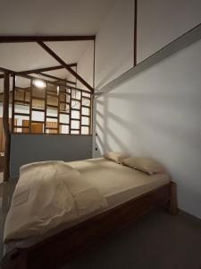 a bed in a room with a white wall at Onaza Homestay Bintang in Katiet