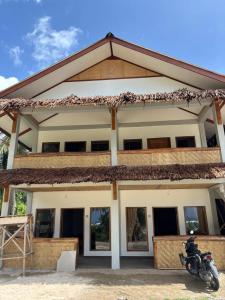 a house with a motorcycle parked in front of it at Onaza Homestay Bintang in Katiet