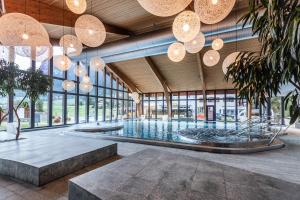 a large swimming pool in a building with chandeliers at Hotel Fravi in Andeer