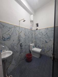 a bathroom with a toilet and a sink at Hotel Town Inn in Mathura