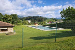 a fence in a yard with a swimming pool at Nova MSuites Xove in Lago