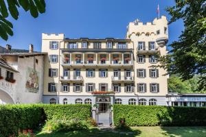 a large white building with bushes in front of it at Hotel Fravi in Andeer