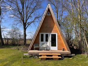 a small house with a porch and two chairs in it at Tiny House 'The Cabin' in Berlicum