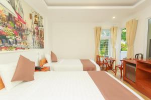a hotel room with two beds and a television at HP Truong Hotel Phu Quoc in Phú Quốc +69 photos