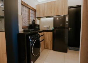a kitchen with a black refrigerator and a dishwasher at Bella casa in Siolim