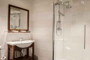a bathroom with a shower, sink, and mirror at The Pilgrim Inn in Southampton