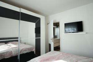 a bedroom with two beds and a flat screen tv at Wasser & Bergwelt Appartement Kärnten in Seeboden