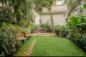 a garden with benches in front of a house at Bella casa in Siolim
