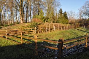 a wooden fence in front of a field at Dworek Bogdanka in Trzebin