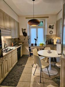a kitchen with a table and a white table and chairs at Lake apartment with terrace in Nidau