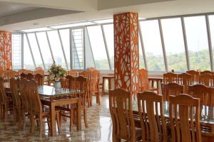 a dining room with tables and chairs and windows at HP Truong Hotel Phu Quoc in Phú Quốc