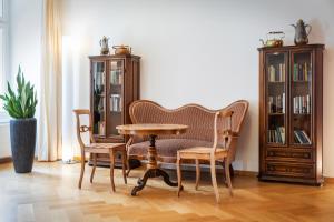 a table and chairs in a room with bookshelves at Hotel Fravi in Andeer
