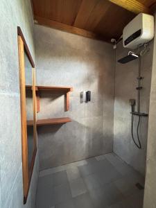 a bathroom with a shower with a fan and a shower at Onaza Homestay Bintang in Katiet